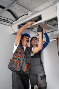Workers installing a duct system in a building, demonstrating HVAC expertise and installation services.